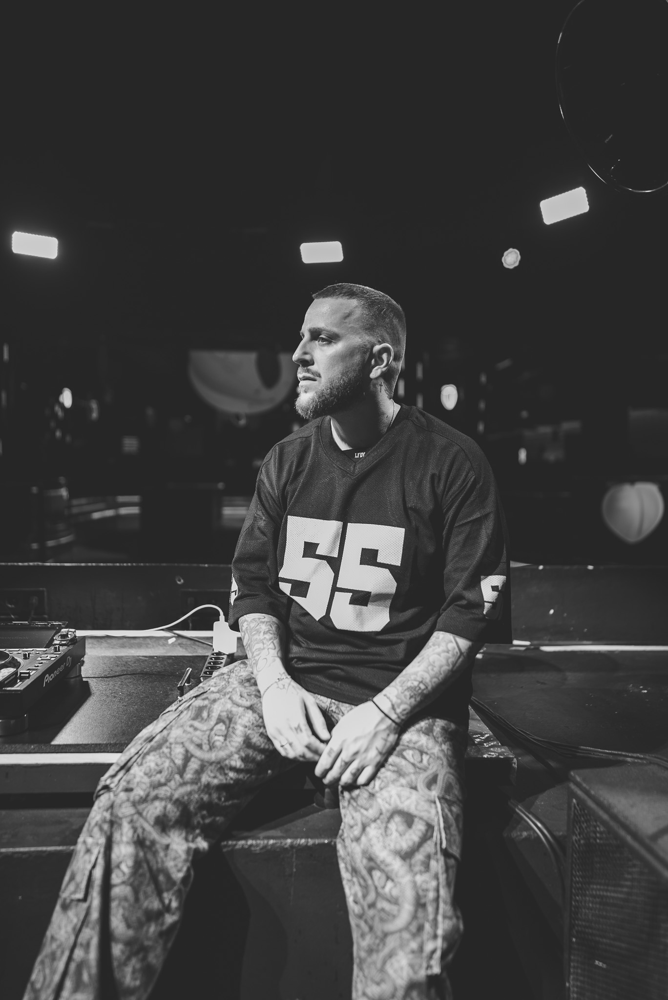Portrait of DJ AND-J seated at a DJ booth