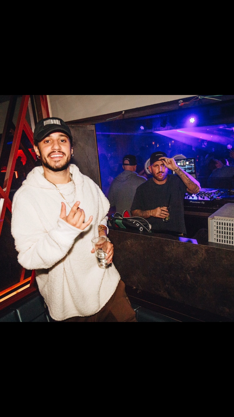 DJ AND-J and an artist at a club booth